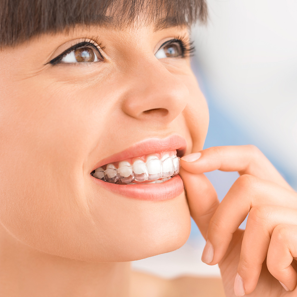 A person is holding up a small, clear plastic tray with a single toothbrush-shaped object inside it.